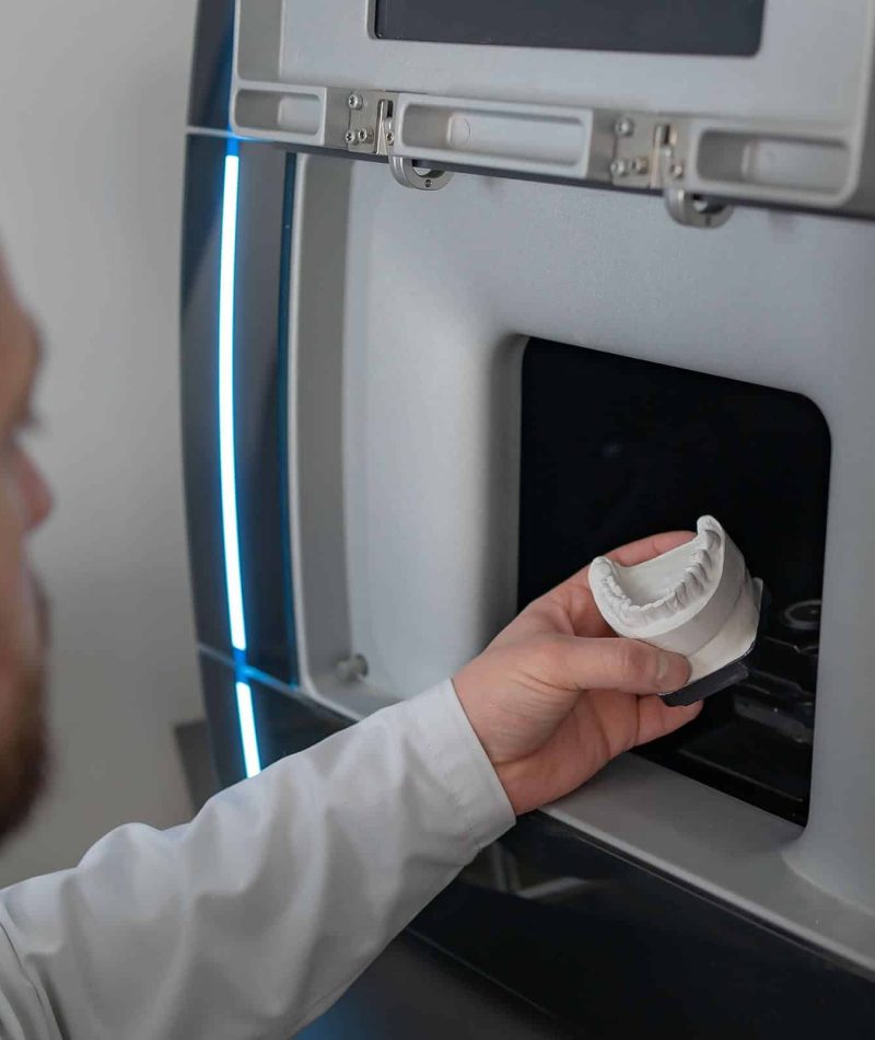 Technician put prosthesis in dental 3D scanner. Close-up of a de